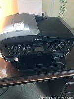 Front angled view of Canon MX850 printer showing control panel and scanner lid.