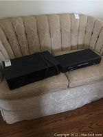 Side by side photo of the Emerson DVD/CD player and the Onkyo cassette tape deck on a beige couch.