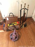 Full view showing fireplace tools, leather log holder, DuraFlame firelog, and basket with firestarters on wood floor