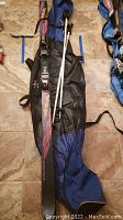 Volkl skis, Rossignol poles, and blue/black storage bag packed and laid out on floor.