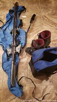 Photo showing Head Cyber X44 skis placed on top of blue storage bag alongside Dalbello ski boots and a blue bag.