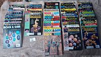 Overview of all Rock and Gem magazines laid out on blanket showing different years and issues from 1997-2002 as full and near full sets.