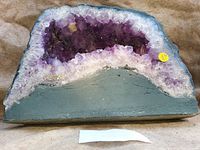 Front view of amethyst cathedral geode showing deep purple crystals and lighter edges on cloth background