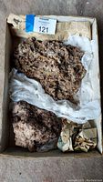 Two large wulfenite specimens placed in a box lined with newspaper and protective tissue paper.