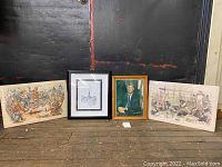 Four prints shown including two political satire pieces on the ends, JFK portrait in wooden frame and Paris pen and ink print in black frame in the middle.