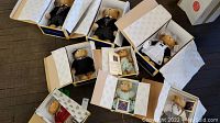 Eight Beverly Hills collector's teddy bears in original boxes with tissue paper. Bears wear various outfits including suits, maid uniform, striped pajamas, and casual wear. Each bear comes with certificate of authenticity.