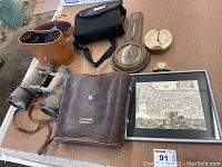 Overview of all lot items including binoculars, barometer, clocks and Mediterranean map.