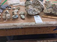 Overview of assorted rocks and pebbles laid out on a surface. Includes small to large sized stones with various textures and mineral composition.