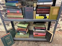 Shelves filled with approximately 27 hardcover vintage and antique books with various titles on sport, history, biography, poetry, music study, and military history.