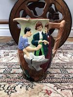 Front side showing the blacksmith, groom, and bride in period attire in relief detail on the ceramic pitcher.