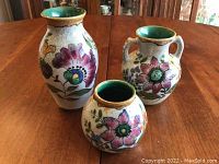 Three Royal Zuid Holland Gouda ceramic vases displayed on table, showing full set and painted floral details