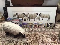 Wide view of framed watercolor, ceramic sheep figurine and decorative plaques on patterned rug