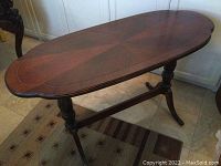 Front angle showing the oval top with diamond pattern and turned legs with stretcher base.