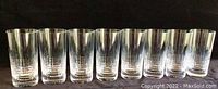 Eight Baccarat Nancy crystal highball glasses arranged in a row against a dark background