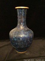 Full view of the blue cloisonné vase showing gold floral designs and gold trim at rim and base.