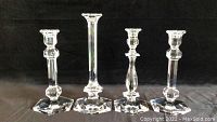 Four Val Saint Lambert clear crystal candle holders showing different designs and heights.