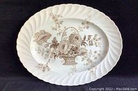 Photo of Royal Staffordshire oval porcelain platter with floral basket design in brown on white background, showing the scalloped edge and central motif