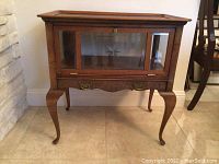 Front view of walnut antique drink cabinet with glass etched front and cabriole legs