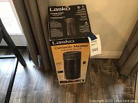 Boxed Lasko ceramic heater showing front and side with product information and branding.