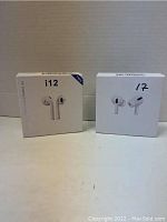 Two boxes of wireless earbuds shown side by side, one i12 model and one AirPods style, both with pictures of earbuds on front indicating contents.