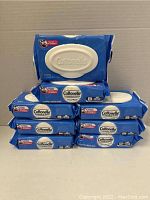 Image showing all eight packs stacked together in a pyramid shape, featuring the blue plastic packaging with white flip-top lid and Cottonelle branding.