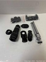 Overview of contents including telephoto lens, tripod, remote shutter, lens caps, and mounting accessories in plastic bags.