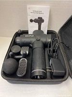 Ekupuz massage gun with five interchangeable massage heads, charger, and instruction manual arranged inside a black carrying case.