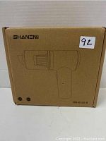 Box of Shanen mini handheld cordless vacuum cleaner SN-6102-S showing line drawing of vacuum on front with branding and model number.