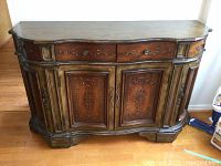 Front view of wood buffet cabinet showing four curved top drawers and two central carved doors with metal knobs, and painted distress details.