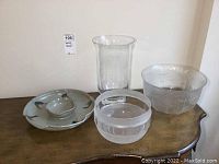Lot arranged on wooden surface showing two glass bowls, one glass vase, and ceramic chip and dip plate.