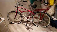 Full left-side view of red and white cruiser bicycle standing in room