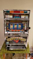 Front view of chrome tabletop slot machine with Seven League decal and Big Chance Game graphics