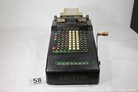 Front view of the antique Victor adding machine showing key layout, display window, and brand name.