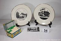Full lot with two collectible plates, vintage metal recipe box and postcard arranged on display with inventory tag visible.