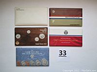Five unopened uncirculated coin sets in original U.S. Mint packaging for years 1981, 1984, 1985, 1987, and 1991.
