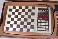 Full view of the electronic chess board and control panel in wooden box, showing square grid, labels, and chess piece storage area.