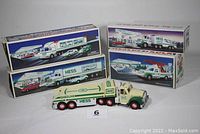 Five Hess toy trucks in original boxes, one truck out of box in front, showing size and box design.
