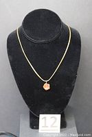 Full view of necklace displayed on black bust showing chain style and pendant position.