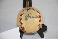 Photo of Rawlings Official National League baseball signed by Mike Schmidt displayed on a black stand.