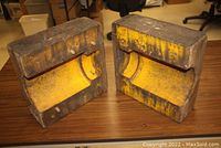 Both wooden pattern halves side by side showing yellow-painted cavity interiors