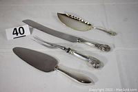 Full view of four sterling silver serving pieces on white background with lot number '40'.