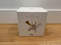 Box packaging showing the ceramic moose wall decor from Indigo with a white and gold moose image on front.