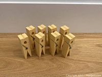 Set of 8 oversized painted MDF clothes pins arranged in rows showing front and side profiles with metal springs visible.