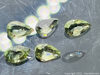 Top view of five pear-shaped mint green sapphires showing clarity and color.