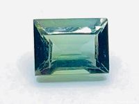 Close-up front photo of the green tourmaline gemstone with visible internal clarity and baguette cut facets.