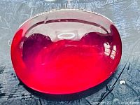 Top view of the oval dome-shaped ruby showing color and polish