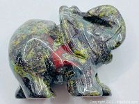 Side view of the polished Dragon's Blood Jasper elephant figurine showing its coloration and details.