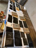 Overview of loose glass negatives and six labeled paper boxes on table
