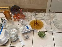 Full lot overview showing various carnival glass, clear glass dishes, and hen on nest covered dishes on floor.