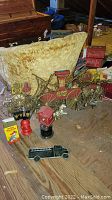 Large plastic fire truck plaque displayed with replica fire alarm box and small black fire truck decor.